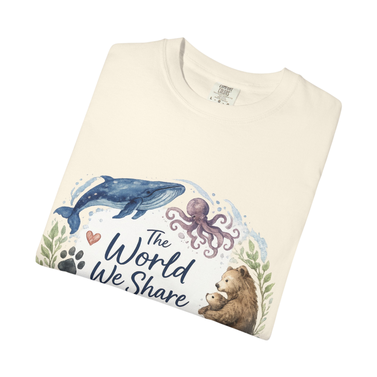 A folded cream-colored t-shirt with a watercolor-style graphic on the front showing a blue whale, purple octopus, brown bear, and the text 'The World We Share'.