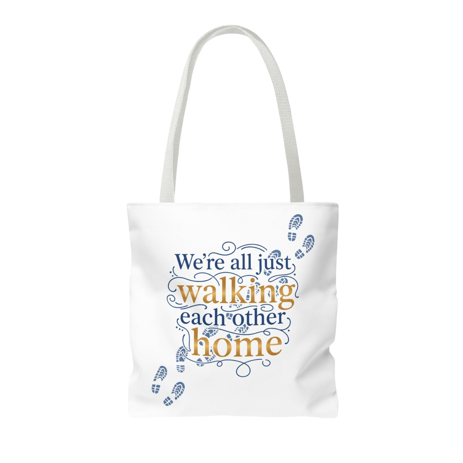 A white canvas tote bag with white shoulder straps, featuring a printed graphic on the front. The graphic displays the phrase 'We're all just walking each other home' in blue and orange lettering, decorated with blue baby footprints.