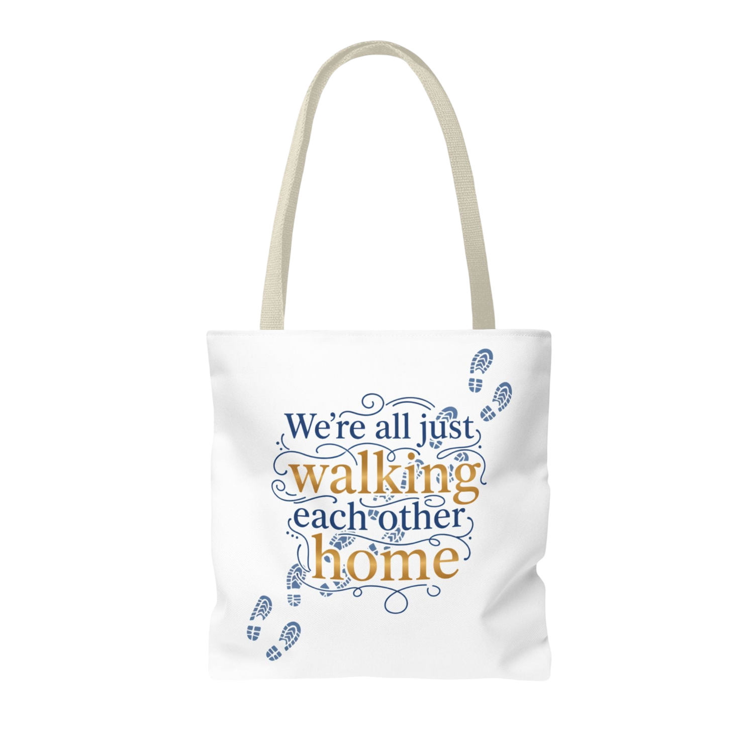 A white canvas tote bag with beige handles, featuring the printed phrase 'We're all just walking each other home' in blue and orange lettering with blue footprint illustrations.
