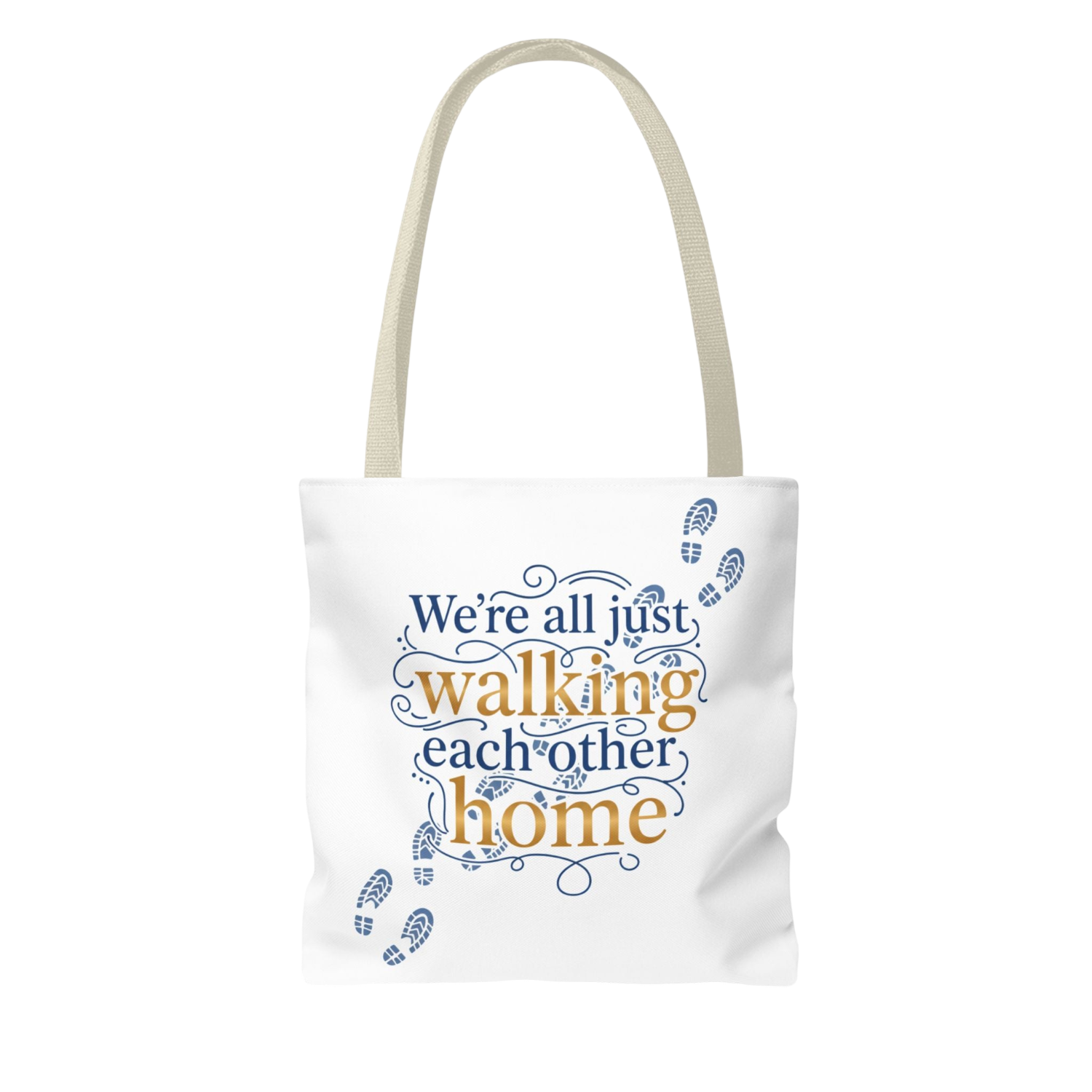 A white canvas tote bag with beige handles, featuring a printed graphic on the front that reads 'We're all just walking each other home' in blue and gold lettering, accented with blue footprint illustrations.